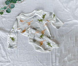 Cute baby in a dinosaur-themed romper from Ju Ju Jam