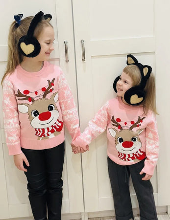 Children playing in the snow while wearing the Charming Girls Cozy Reindeer Sweater, adding warmth and holiday spirit.