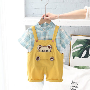 Charming baby boy in a Checkered Bear Pocket jumpsuit, showcasing a playful bear design from Ju Ju Jam.