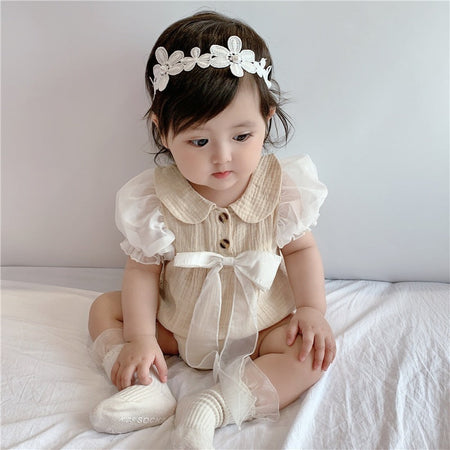 Charming baby girl in a My Lady romper with a bow detail, designed for elegance from Ju Ju Jam.