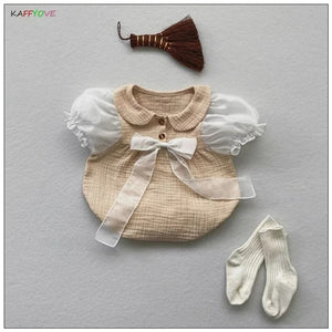 Charming baby girl in a My Lady romper with a bow detail, designed for elegance from Ju Ju Jam.