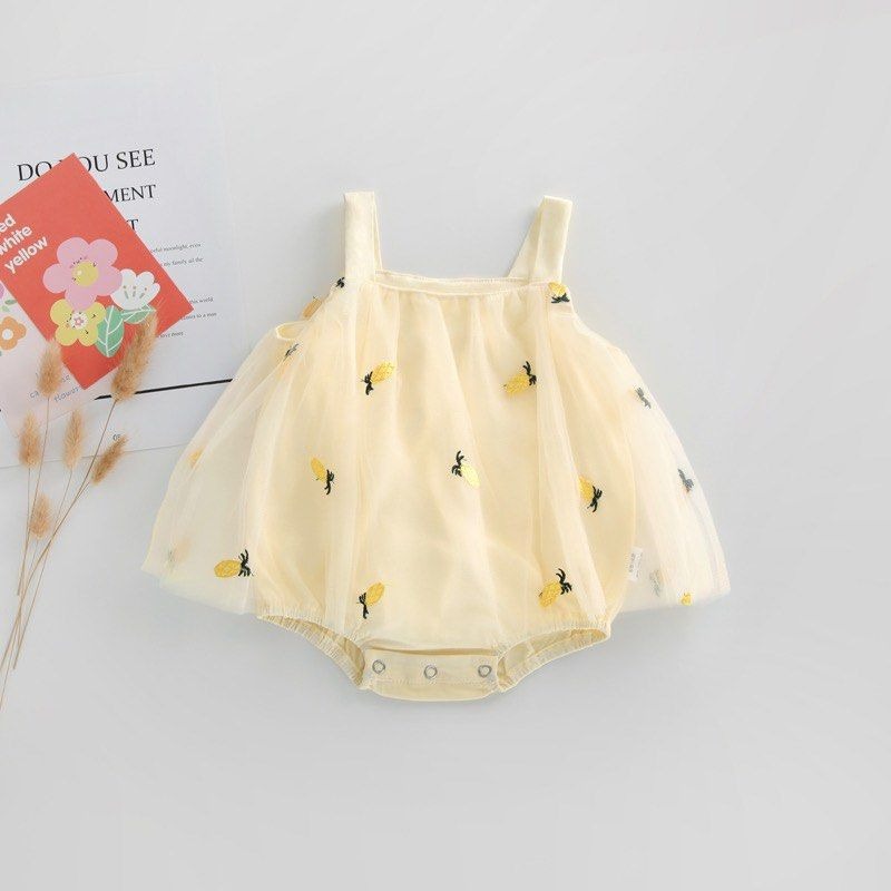 Infant dressed in a cute pineapple print frill romper dress from Ju Ju Jam.